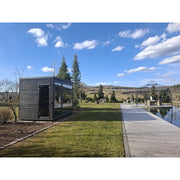 KOBA Fenris Gartensauna - Designsauna aus dunklem Holz im modernen Garten mit Teich und Landschaftsblick