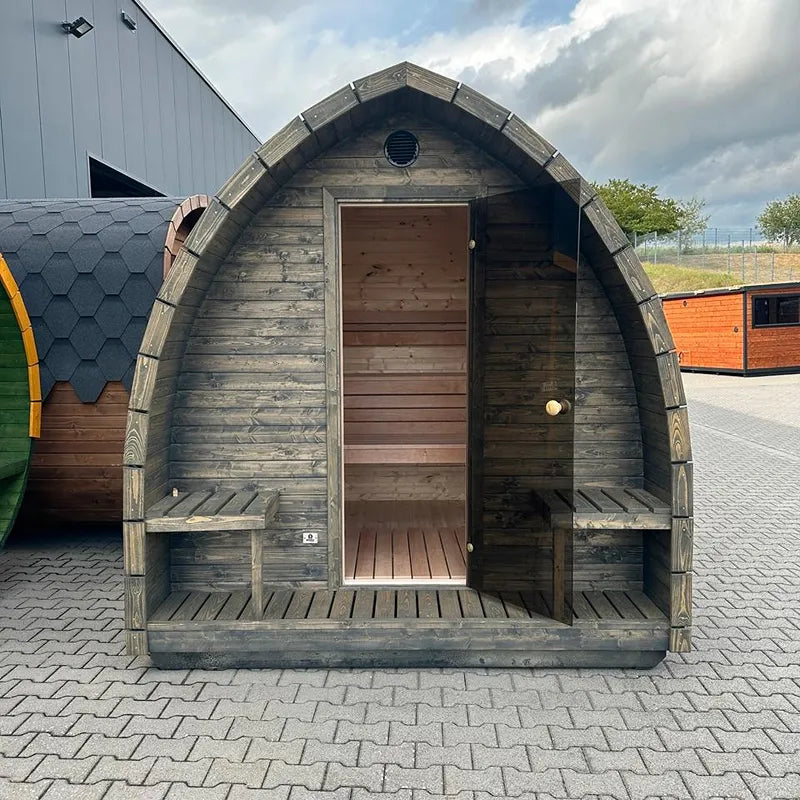 KOBA Iglu Gartensauna mit charakteristischer Iglu-Form, Holzfassade und offener Tür auf Pflasterfläche
