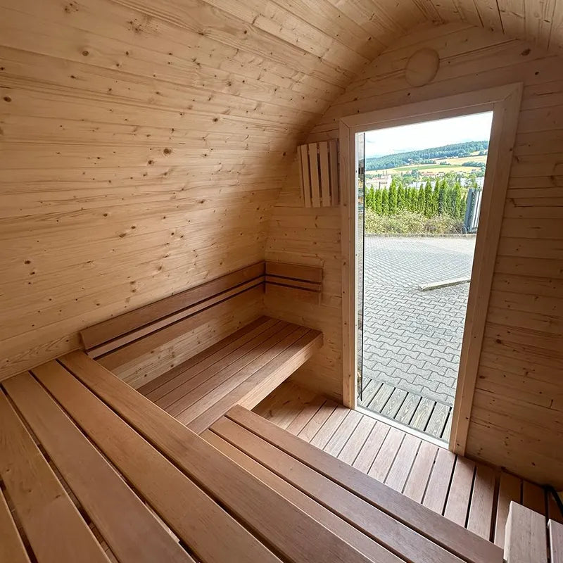 KOBA Iglu Gartensauna Innenraum mit Holzbänken und gewölbter Iglu-Form, Blick auf Garten