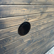 KOBA Iglu Gartensauna Detail: Schwarzes Lüftungsgitter in Holzwand der Iglu-Sauna