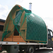 KOBA Iglu Gartensauna mit charakteristischer Iglu-Form auf Transportfahrzeug, Holzkonstruktion mit grünem Schutznetz