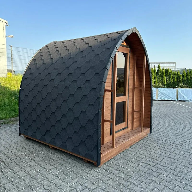 KOBA Iglu Gartensauna mit charakteristischer Iglu-Form, schwarzes Schindeldach und Holzfront in Garten