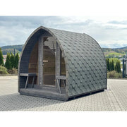 KOBA Iglu Gartensauna mit charakteristischer Iglu-Form in Grau, aufgestellt auf Pflastersteinen im Garten mit Landschaftsblick