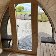 KOBA Iglu Gartensauna mit charakteristischer Iglu-Form, Blick aus geöffneter Tür auf Gartensaunaplatz mit mehreren Saunen