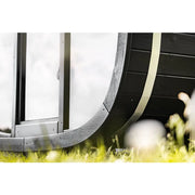 Leil® Black Cube Comfort Gartensauna von Leil® Saunas mit schwarzer Holzverkleidung und metallischem Streifen im Garten