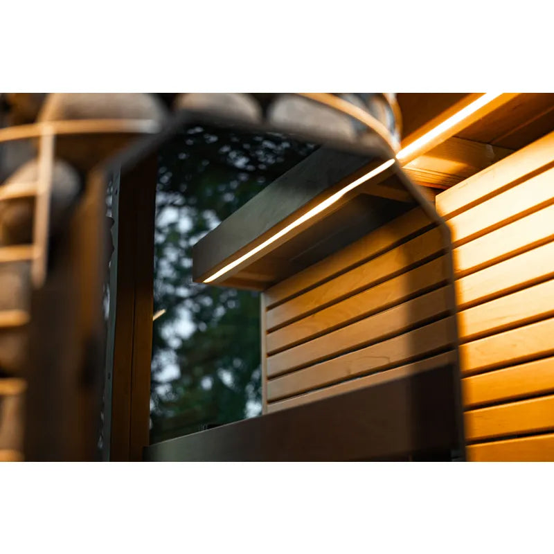 Leil® Black Cube Comfort Gartensauna mit beleuchteter Holzbank und schwarzem Rahmen im Garten