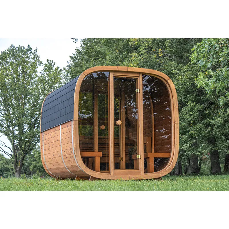 Leil Dice Dual Gartensauna von Leil Saunas mit 4 Personen Kapazität, modernes Design mit Holzverkleidung und großen Glasfenstern, im Garten zwischen Bäumen