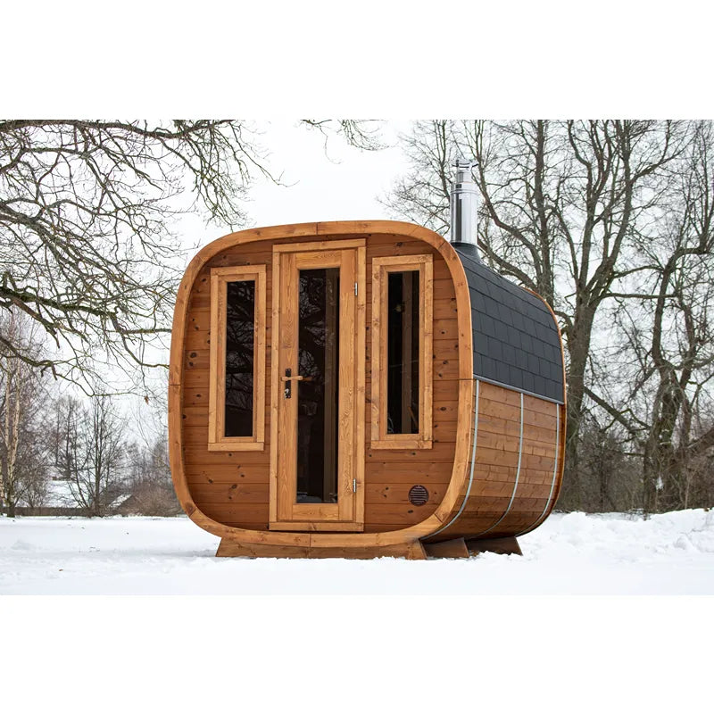 Leil Dice Dual Gartensauna von Leil Saunas mit Holzfassade, zwei Räumen und Saunaofen im Schnee