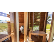 Leil Dice Dual Gartensauna von Leil Saunas mit Holzbank, Saunaofen und großer Glasfront im Garten