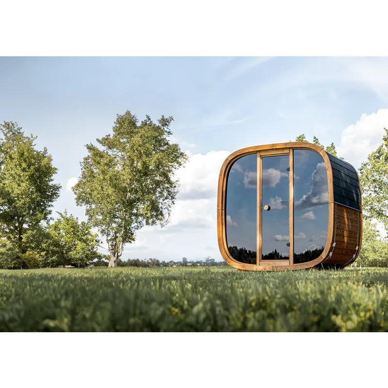 Leil Dice Pocket – Kompakte Gartensauna 4 Personen mit würfelförmigem Design aus Holz auf einer Wiese