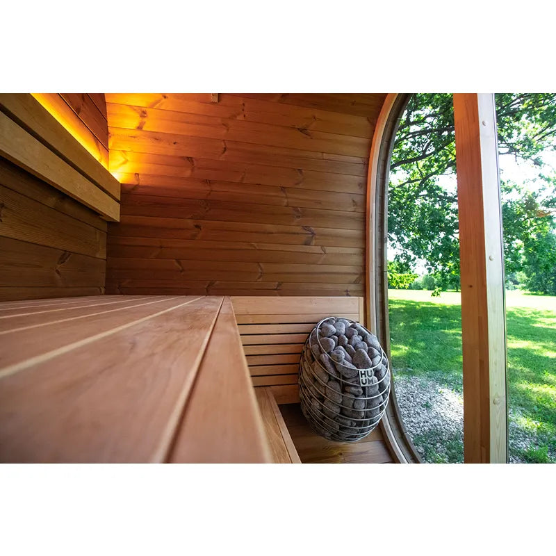 Leil Dice Pocket Gartensauna Innenraum mit Holzbänken, Saunasteine und Gartenblick