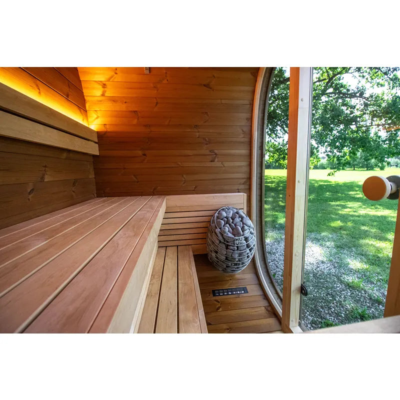 Leil Dice Pocket Gartensauna Innenraum mit Holzbänken, Saunaofen und Gartenblick durch Fenster