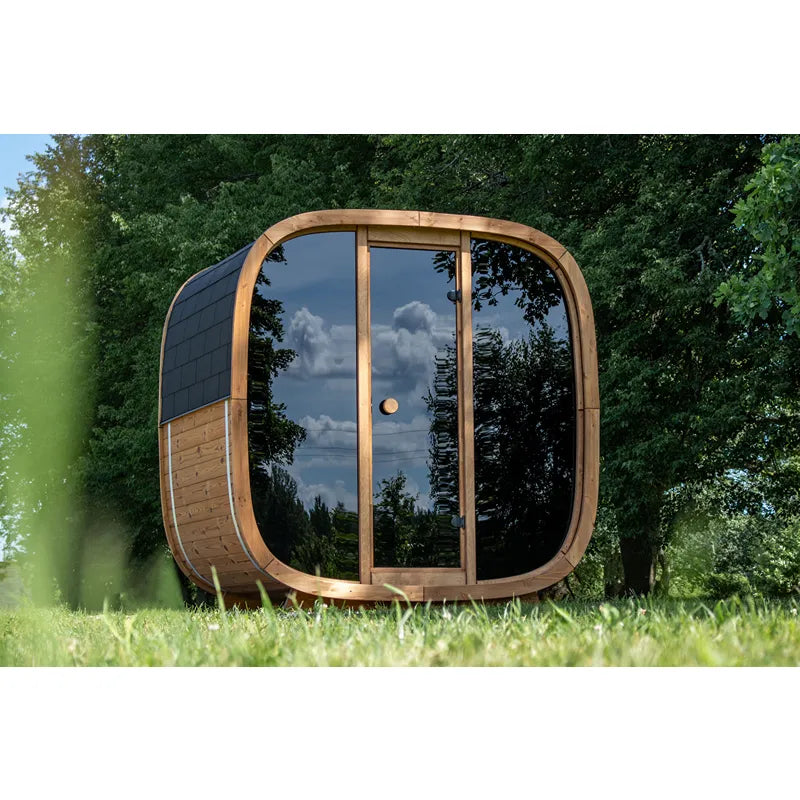 Leil Dice Pocket kompakte Gartensauna 4 Personen mit rundlichem Design, Holzrahmen und großen Glasfenstern im grünen Garten