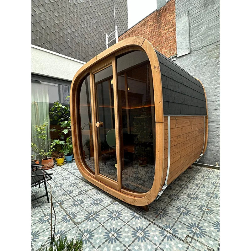 Leil® Dice Solo Gartensauna 5 Personen 4,5 m² mit Holzrahmen und großen Glastüren im modernen Innenhof