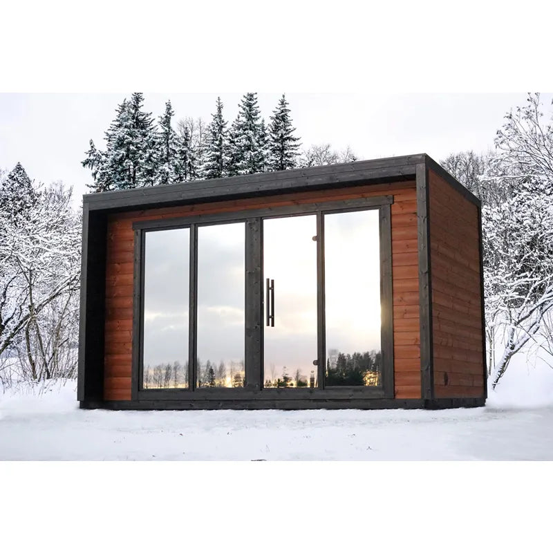 Leil® Patio L Gartensauna 5 Personen 9,6 m² von Leil® Saunas mit Holzfassade und großen Glastüren im verschneiten Garten