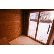 Leil® Patio L Gartensauna Innenraum mit Holzbänken, großen Fenstern und Blick auf verschneiten Garten
