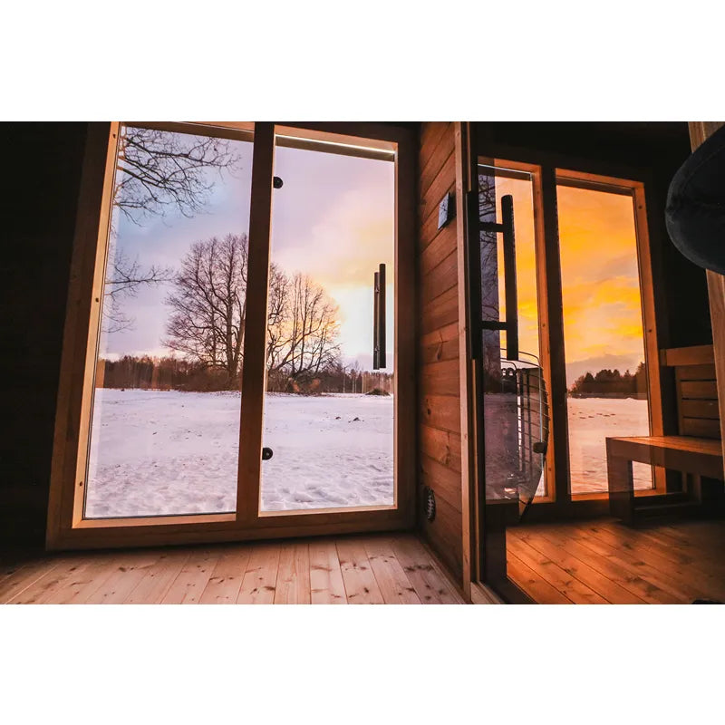 Leil® Patio L Gartensauna von Leil® Saunas mit offener Tür, Holzinnenraum und Ausblick auf verschneite Winterlandschaft bei Sonnenuntergang