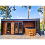 Leil Patio L Plus Gartensauna mit Überdachung und Whirlpool im Garten zwischen Bäumen