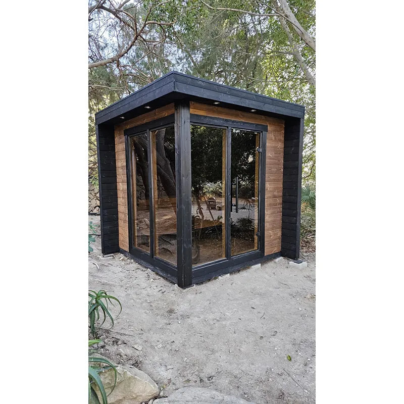 Leil Patio S Gartensauna 4 Personen von Leil Saunas mit schwarzer Verkleidung und Holzakzenten im Garten