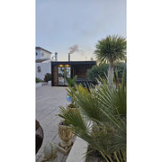 Leil Patio S Plus Gartensauna mit Überdachung im modernen Garten mit Palmen und Terrasse