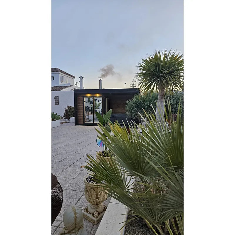 Leil Patio S Plus Gartensauna mit Überdachung im modernen Garten mit Palmen und Terrasse