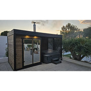 Leil Patio S Plus Gartensauna mit Überdachung von Leil Saunas in schwarzem Design mit Glastür und Whirlpool im Garten