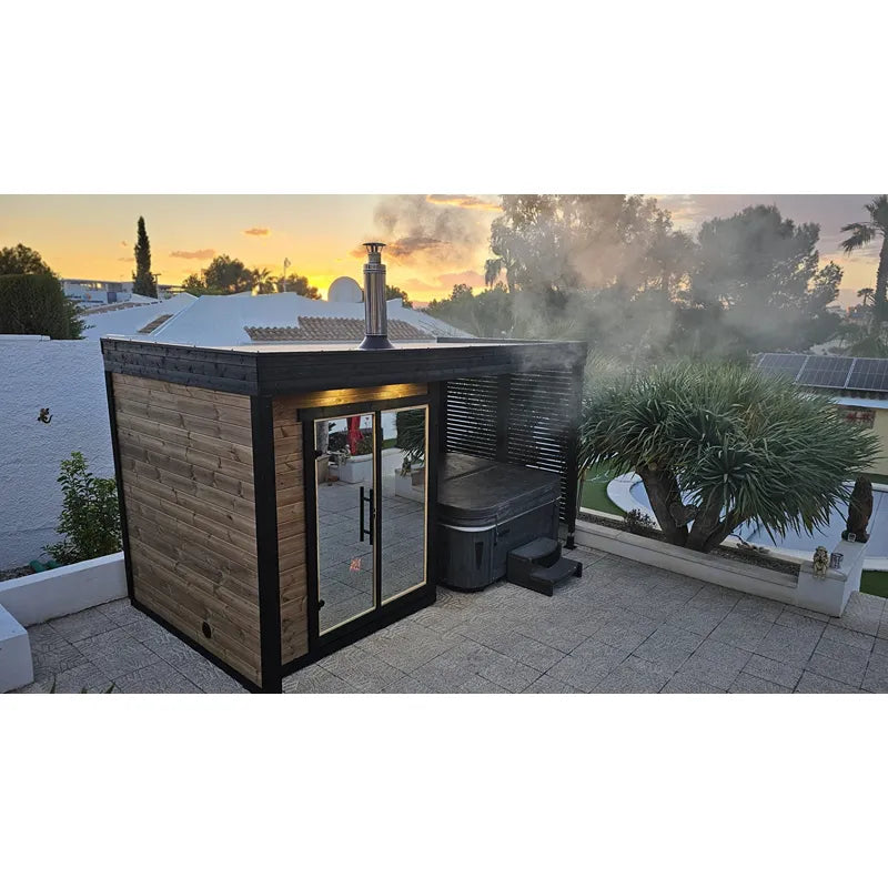 Leil Patio S Plus Gartensauna mit Überdachung und angebautem Whirlpool im Garten bei Sonnenuntergang