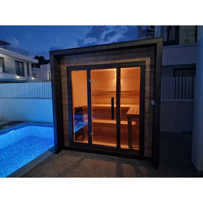 Leil® Patio XS Gartensauna von Leil® Saunas mit Holzinnenraum, Sitzbänken und beleuchteten Glastüren im Garten bei Dämmerung