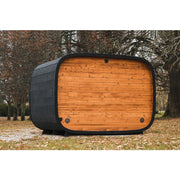 Leil® Round Cube Double Premium Gartensauna 2 Räume mit rundem Design, schwarzem Rahmen und orange Holzfassade im Garten