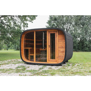 Leil® Round Cube Double Premium Gartensauna 2 Räume mit rundlicher Form, Holzfront und dunklem Außenbereich im Garten