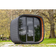 Leil Round Cube Mini Gartensauna 4 Personen von Leil Saunas mit schwarzem Design und Holzakzenten im Garten