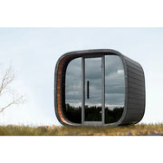 Leil Round Cube Mini – Gartensauna 4 Personen von Leil Saunas mit schwarzem Schindeldach und großen Glastüren im Gartenbereich