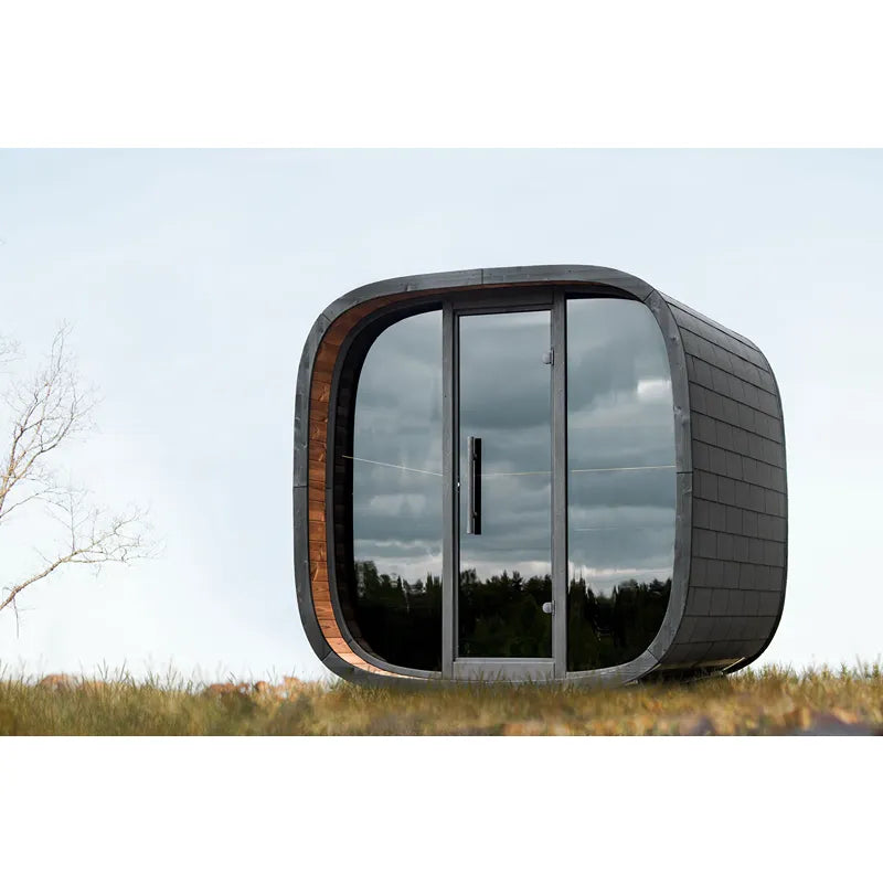 Leil Round Cube Mini – Gartensauna 4 Personen von Leil Saunas mit schwarzem Schindeldach und großen Glastüren im Gartenbereich