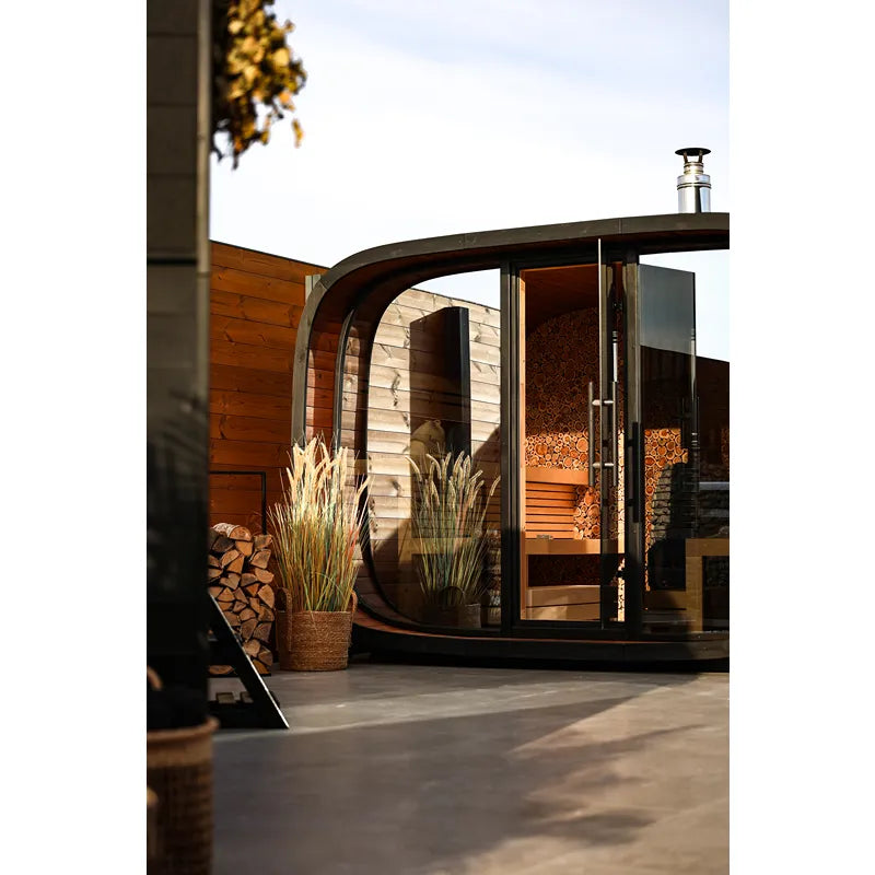 Leil Round Cube Single – Premium Gartensauna 1 Raum von Leil Saunas im Garten mit rundem Design, Holzverkleidung und großen Glastüren