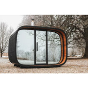 Leil Round Cube Single – Premium Gartensauna 1 Raum von Leil Saunas mit rundem Design, schwarzem Außengehäuse und großen Glasfenstern in Winterlandschaft