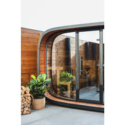 Leil Round Cube Single Premium Gartensauna mit rundem Design, Holzverkleidung und großen Glastüren im Garten