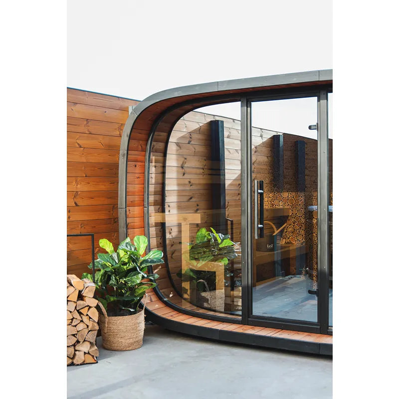 Leil Round Cube Single Premium Gartensauna mit rundem Design, Holzverkleidung und großen Glastüren im Garten