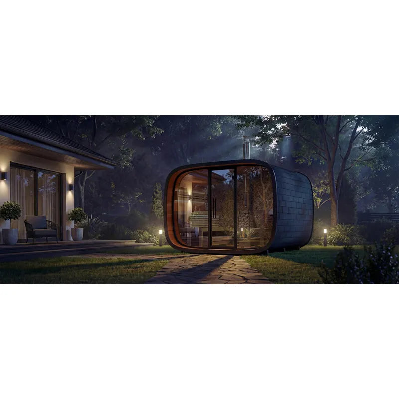 Leil Round Cube Single Premium Gartensauna 1 Raum mit abgerundeter Form im Garten, beleuchtet am Abend