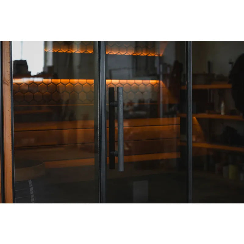 Leil® Viva 250 Gartensauna von Leil® Saunas – Schwarzer Türgriff an Glasfront mit Blick auf Holzbänke innen