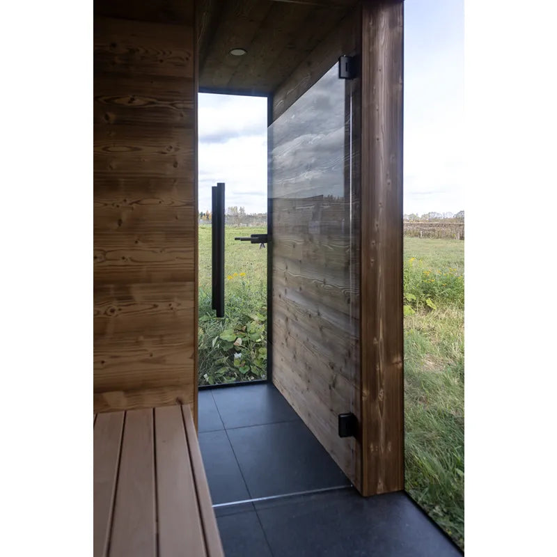 Nordik Wellness Signature L Premium-Gartensauna mit offener Tür, Holzinnenraum und Blick auf grüne Gartenlandschaft