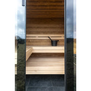 Nordik Wellness Signature M Gartensauna Innenraum mit Holzbänken und schwarzem Aufgusseimer