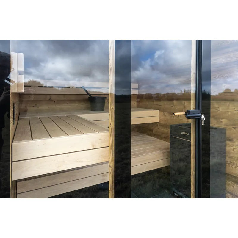 Nordik Wellness Signature M Kompakte Luxus-Gartensauna mit Holzbank und großen Glasfenstern in Gartenumgebung