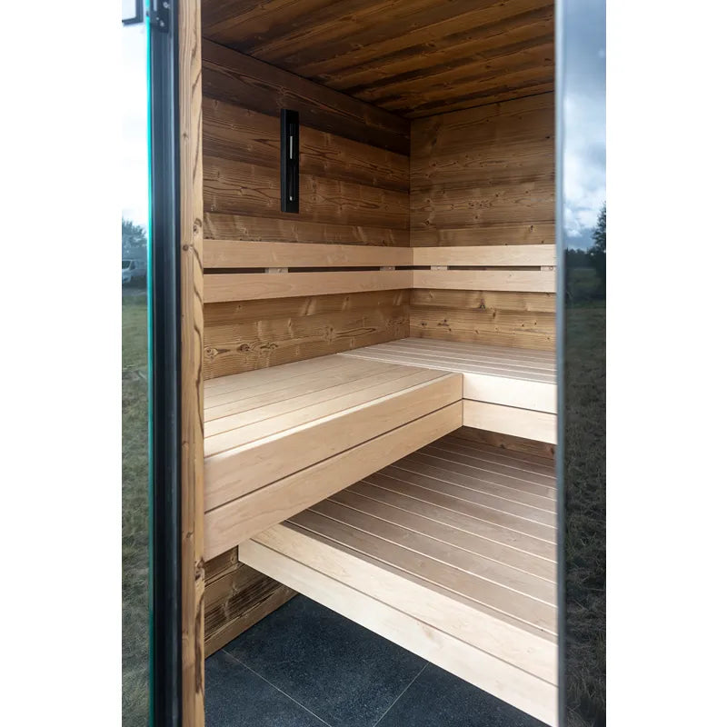 Nordik Wellness Signature M Gartensauna Innenraum mit Holzbänken und schwarzer Ofen-Verkleidung