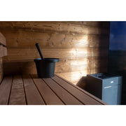 Nordik Wellness Signature M Kompakte Luxus-Gartensauna Innenraum mit Holzbänken, schwarzem Kübel und Saunaofen