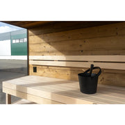 Nordik Wellness Signature M Kompakte Luxus-Gartensauna Innenraum mit Holzbänken und schwarzem Aufgusspimer
