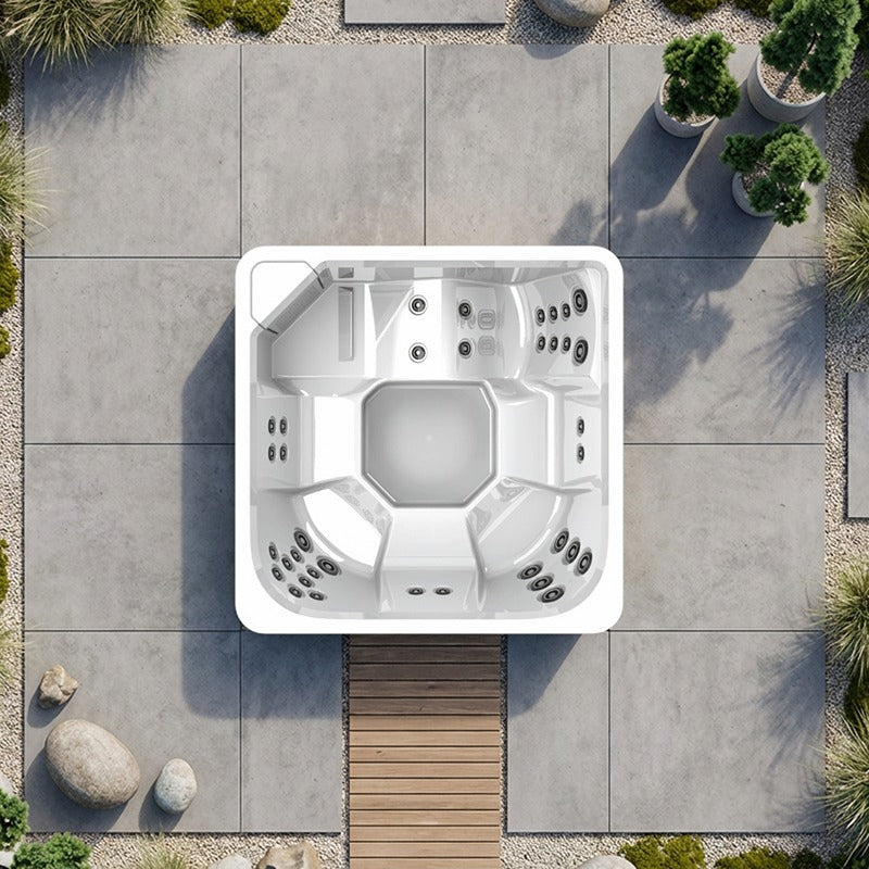 Draufsicht auf einen weißen quadratischen Novitek M-1 Outdoor Whirlpool mit Massagedüsen auf einer Terrasse mit Betonplatten und grünen Topfpflanzen.