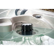 Whirlpool-Steuerventil mit schwarzem Drehgriff in gefülltem Passion Elevate Eisbad, weiße Wanne mit grünlich schimmerndem Wasser und Massagedüsen sichtbar.