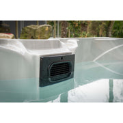 Whirlpool mit integriertem Luftgebläse und Wasseraufbereitungssystem von Passion Spas, gefüllt mit türkisblauem Wasser im Garten