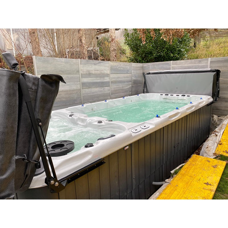Swim Spa im privaten Garten installiert mit geöffnetem Cover – Gegenstromanlage und Whirlpoolbereich in natürlicher Umgebung
