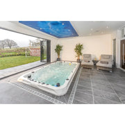 Passion Spas Activity 2 Swim Spa für 3 Personen in modernem Wellnessraum mit Gartenblich, Whirlpool mit türkisem Wasser